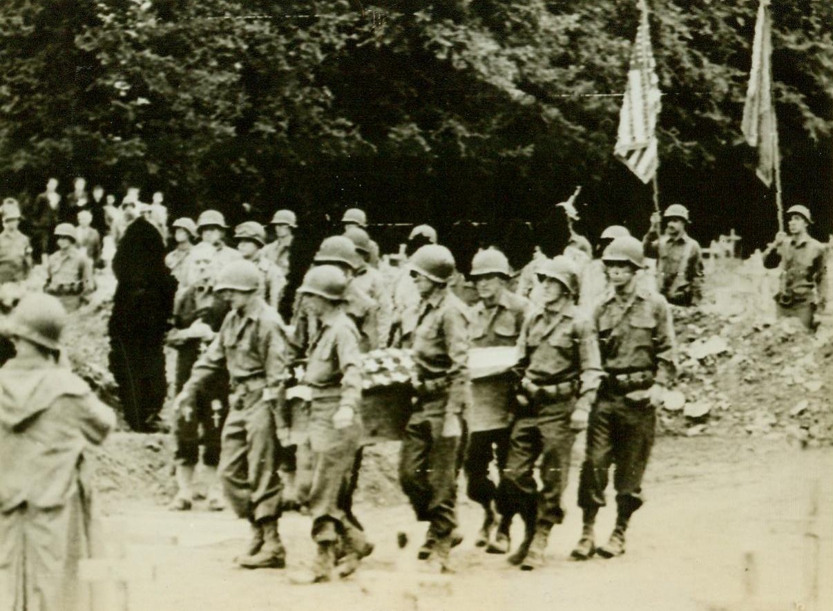 Carry General Roosevelt to Grave, 7/15/1944. France—Eight soldier pallbearers carry the flag-bedecked casket containing the body of Brig. Gen. Theodore Roosevelt to his final resting place in the military cemetery at Ste. Mere Eglise. The beloved General died of a heart attack induced by exhaustion. 7/15/44 (ACME RadioTelephoto);