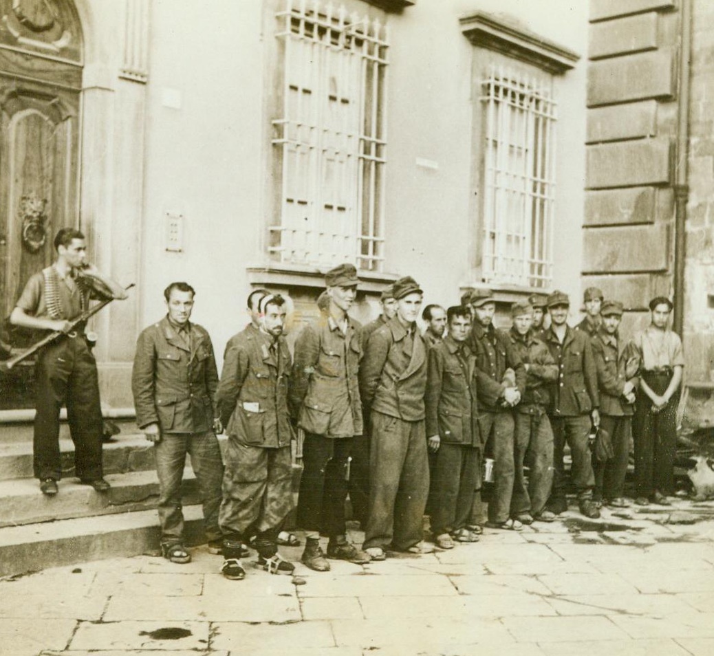 Italian Partisan Guards Nazi Prisoners, 7/20/1944. Italy -- Using equipment taken from Germans they have killed, Italian partisans have been playing their part in the campaign in Italy by rounding up many prisoners and bringing them back to Allied lines. Here, a partisan guards a group of Nazis captured by his band. 7/20/44 (ACME);