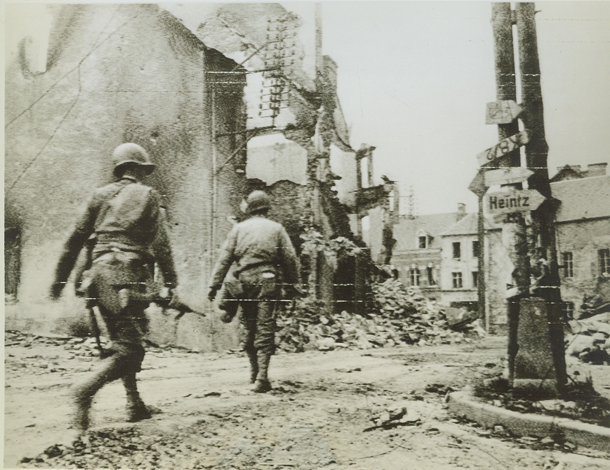 Yanks Mop Up In Marigny, 7/29/1944. France—American soldiers cautiously advance through the ruins of Marigny, France, on the look out for enemy snipers. Last pockets of resistance in the town have been cleaned out by mopping up units.  Credit: Signal Corps radiotelephoto by ACME;