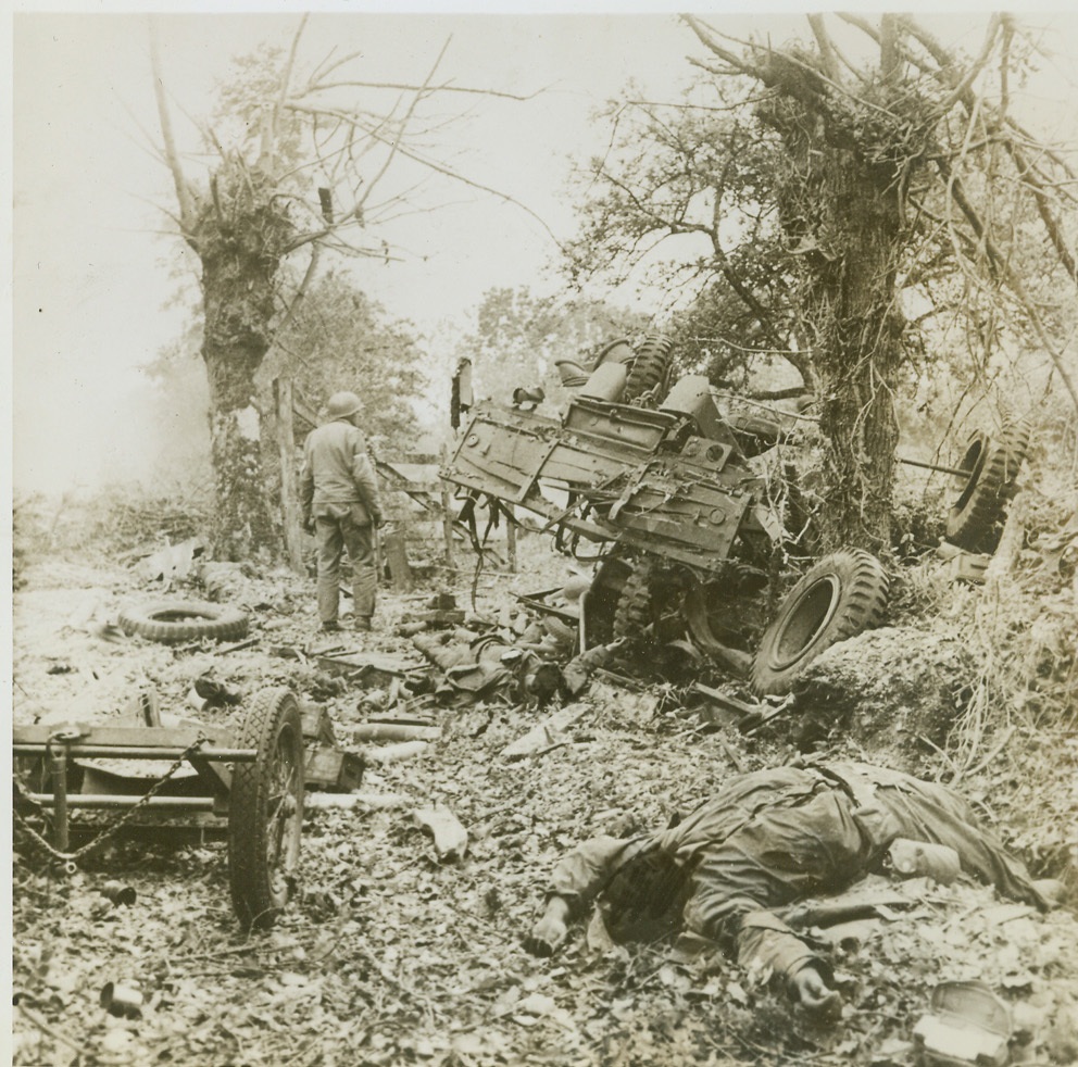 The Price of Victory, 7/13/1944. France—American soldiers lie face turned toward their Maker in death after being hit from mortar shells fired from a Nazi position nearby. Force of the shell’s fire is evidenced by the ruined and upturned Army vehicles in the rear. The price of victory in France is high and the cost is still rising. What better way to lower death tolls and shorten the war than by buying as many war bonds as possible. Credit: ACME;