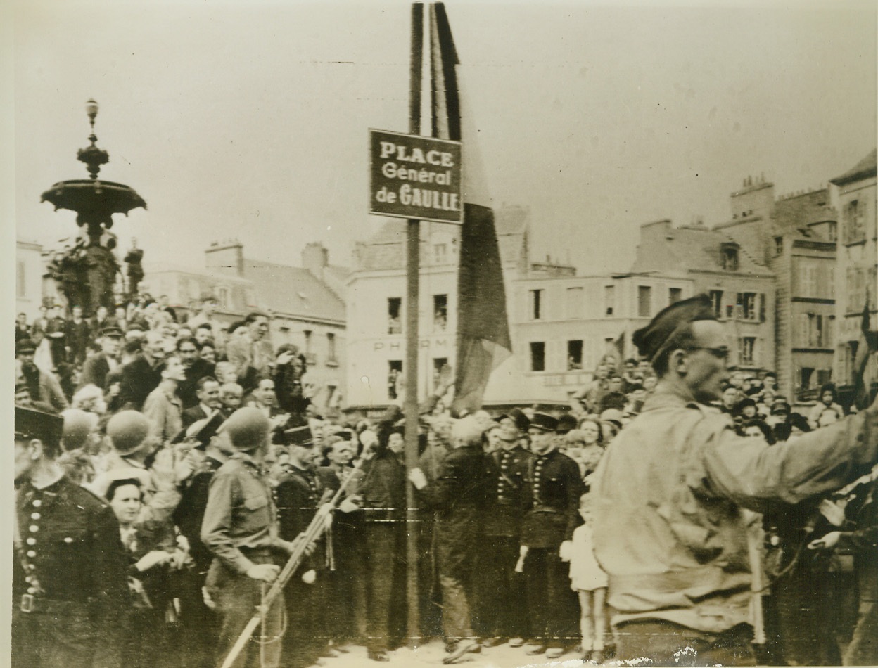 Cherbourg Honors De Gaulle, 7/16/1944. Cherbourg, France—Honoring the general who has carried the banner of French freedom high since the fall of his country in 1940, liberated Cherbourg has renamed its city square. During Bastille Day ceremonies marking the anniversary of French independence, the mayor of Cherbourg unveils the plaque naming the square “Place General de Gaulle.” Credit: Signal Corps radiotelephoto, ACME;