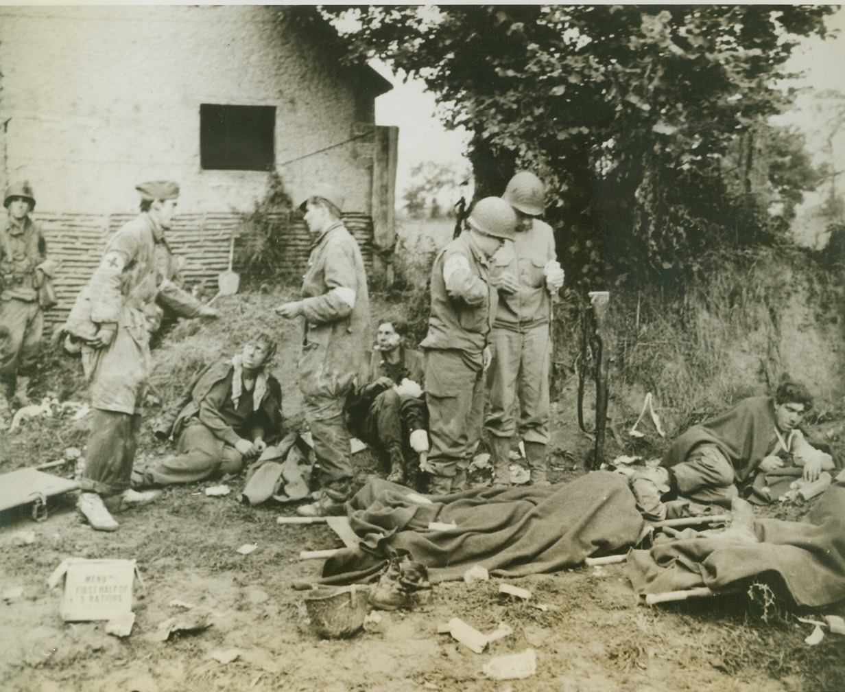 German Prisoners Get Medical Aid, 7/16/1944. St. Lo, France—While two American medical officers quietly go about their job of giving a blood transfusion to a wounded German prisoner (right), two not-so-calm German medical corpsmen discuss in boisterous tones the treatment to be given to a wounded comrade, while the poor fellow under discussion looks at them with unmasked fright. The scene is a temporary dressing station in the St. Lo sector.  Credit: ACME; St. Lo, France—While two American medical officers quietly go about their job of giving a blood transfusion to a wounded German prisoner (right), two not-so-calm German medical corpsmen discuss in boisterous tones the treatment to be given to a wounded comrade, while the poor fellow under discussion looks at them with unmasked fright. The scene is a temporary dressing station in the St. Lo sector.  Credit: ACME;