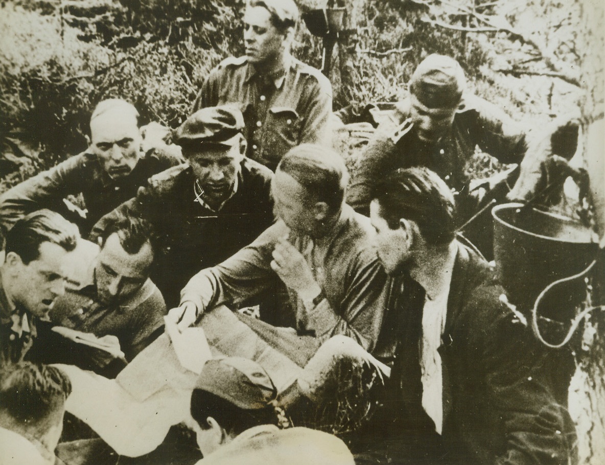 THEY FIGHT TO FREE POLAND, 8/23/1944. POLAND—Guerillas of the Polish Home Army, some wearing uniforms taken from ambushed German soldiers, plan an expedition with their commanding officer. Members of Poland’s 9th Infantry Regiment, the partisans operate behind the German lines. Credit: Acme;