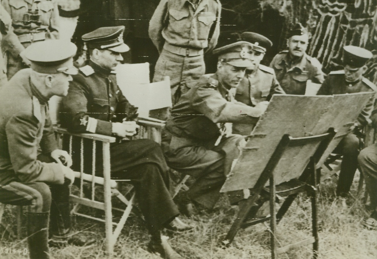 RUSSIAN MISSION VISITS BRITISH FRONT, 8/4/1944. FRANCE—A Russian Military Mission recently visited the British front in Normandy to get a first hand view of how the battles against the Nazis in the west are getting on. Seated as they hear an explanation of battle plans are (left to right): Col. Jorbarov; Vice Adm. Kharlamov; Lt. Gen. Dempsey, commander, British 2nd Army; Maj. Gen. Sklyarov; and Maj. Gen. Vasiliev. Credit (British Official Photo Via Army Radiotelephoto from ACME);