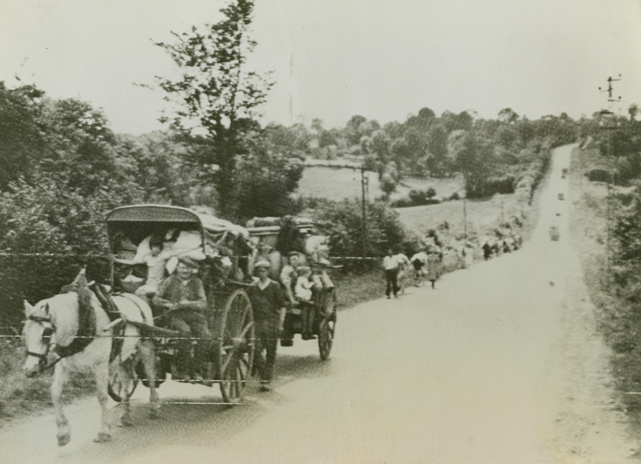 Going Home Again, 8/1/1944. France – A long line of French Evacuees on the Coutances-St. Giles road return with their belongings to their homes. Those in the background are not so fortunate as to have wagons. Credit: US Army Radiotelephoto from ACME;