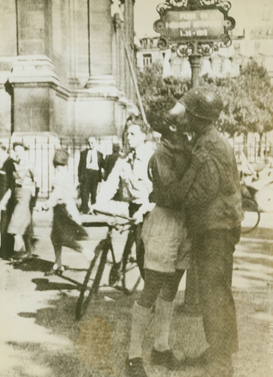 Not Amour – Gratitude, 8/28/1944. Paris – In gratitude for the liberation of his beloved capital, a French civilian gives the traditional exuberant greeting to a Maquis, a member of the French forces which drove the Germans from Paris. Civilians, accustomed to such scenes, pass by with hardly a glance. Credit: Signal Corps Radiotelephoto from ACME;