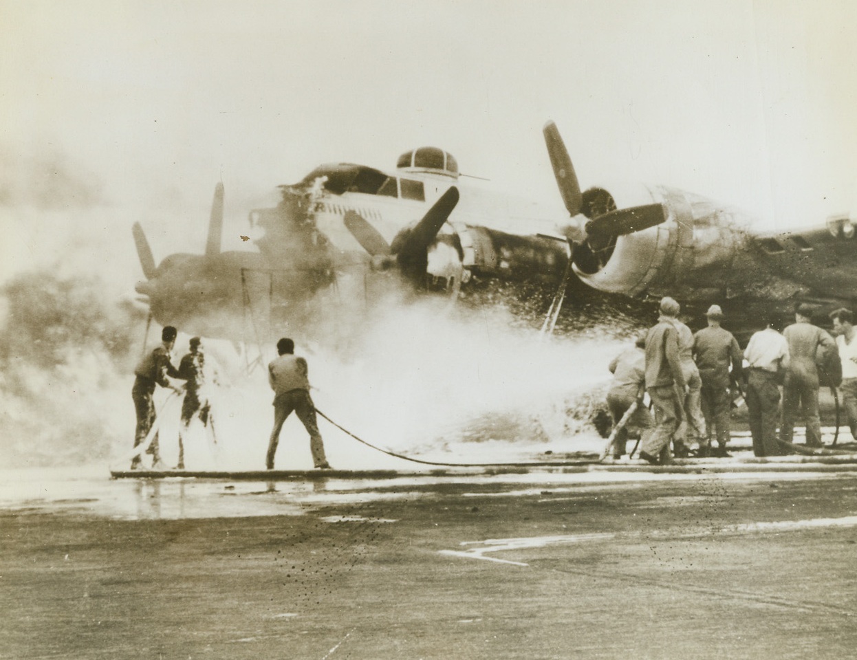 Work on Fired B-17, 8/30/1944. England – An Engineer Aviation Fire Fighting Platoon works hard to put out a fire on a B-17 Flying Fortress at a base in England. Fortresses carry a heavy load of gasoline and often have a full bomb load when fire breaks out. Credit: USAAF photo from ACME;