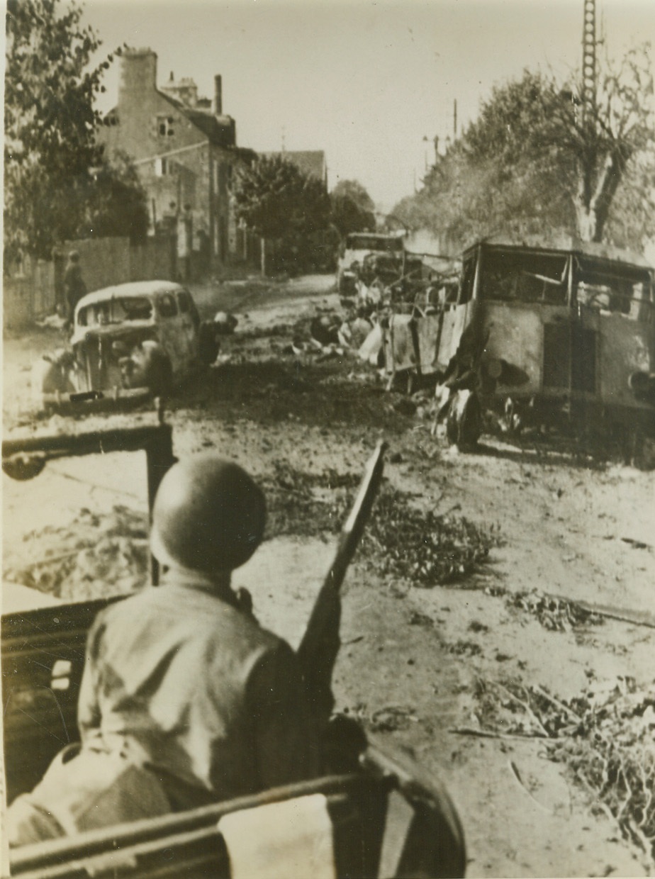 Blasted Nazi Vehicles Greet Yanks, 8/3/1944. France—American forces sweeping through Avranches, are greeted by the sight of destroyed German vehicles lining a street in the town.  Credit: Army radiotelephoto from ACME;