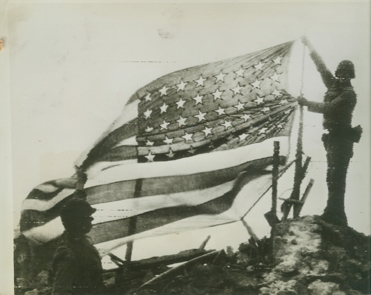 “Old Glory” raised over Cezembre, 9/5/1944. France – The Stars and Stripes are raised over the small French island of Cezembre after German forces had surrendered. Pfc. Richard T. Franz (right), Oswego, N.Y., raises the flag as Pfc. David Snyder of Wilkes Barre, Pa., looks on. The War Department places Cezembre just west of St. Malo off the north coast of Brittany. Credit (Army Radiotelephoto from ACME);