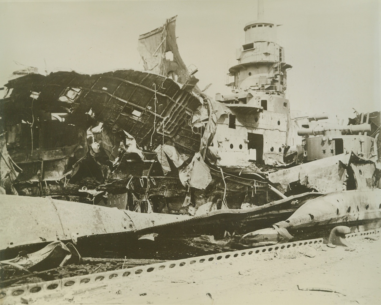Battleship Dunkerque Blasted, 9/15/1944. France – Twisted steel and wreckage are all that remain of the battleship Dunkerque after being blasted by B-17 Flying Forts during a recent raid on the French harbor at Toulon. Credit (USAAF Photo from ACME);
