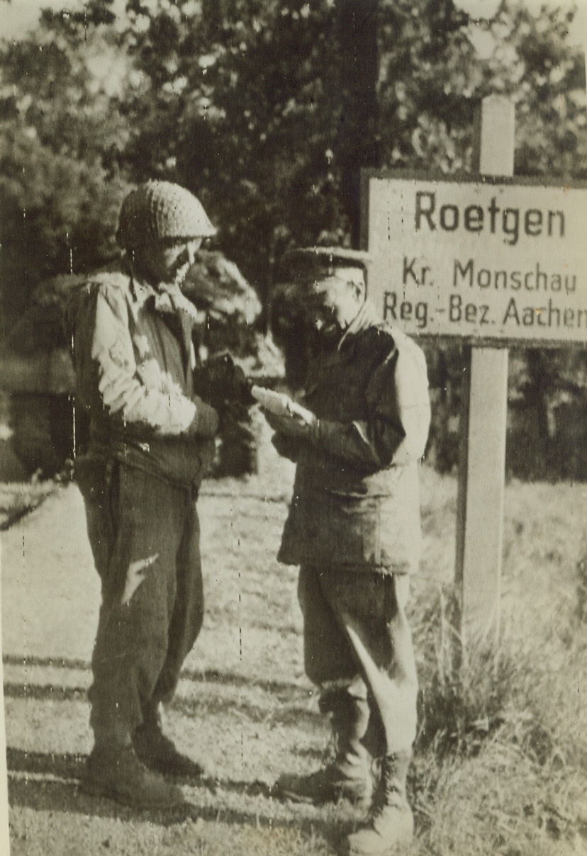 Interview in Germany, 9/15/1944. GERMANY—Along the highway to Aachen, T.R. Henry (right), war correspondent for the Washington, D.C. Star, interviews T/5 Leon Roseman of Weehawken, N.J., Was Department Signal Corps Photographer. Roadside interview took place in the German city of Roetgen. Credit: ARMY RADIOTELEPHOTO FROM ACME;
