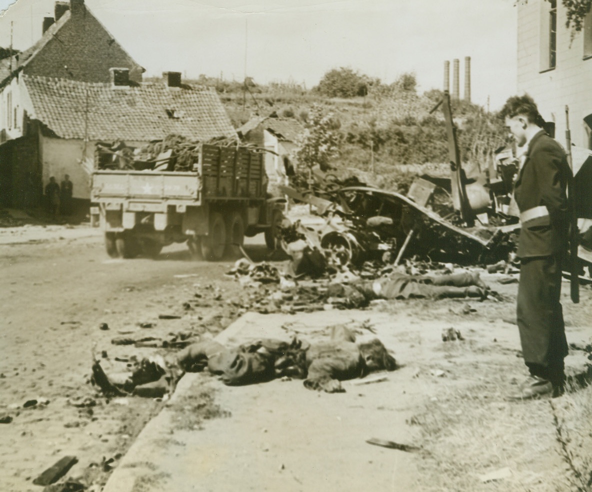 German Dead in Belgium, 9/9/1944. BELGIUM—Face to the pavement, German soldiers lie dead on a street in Gognes Chauvee, Belgium, after being blasted from their vehicles when Allied Aircraft attacked a convoy speeding toward new positions in the face of relentlessly advancing liberating forces. Photo by Andrew Lopez, ACME photographer for the War Picture Pool. Credit: ACME.;