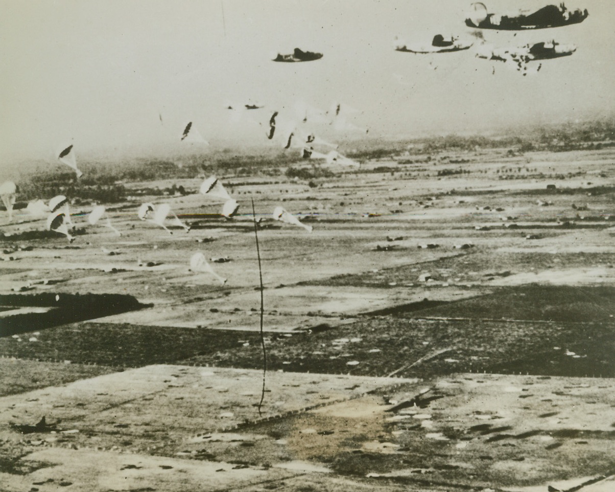 SUPPLIES FOR POCKETED AIR TROOPERS, 9/25/1944.HOLLAND—Liberators of the US 8th Air Force zoom over Holland, dropping parachutes loaded with supplies for paratroopers previously landed in Holland. The countryside is dotted with gliders and collapsed chutes from the initial landings. It has been announced that British 2nd Army troops have crossed the Neder Rhine at Arnhem, establishing contact with the airborne troops who have been pocketed in this area, under steady enemy fire, for a week. Credit: Acme;