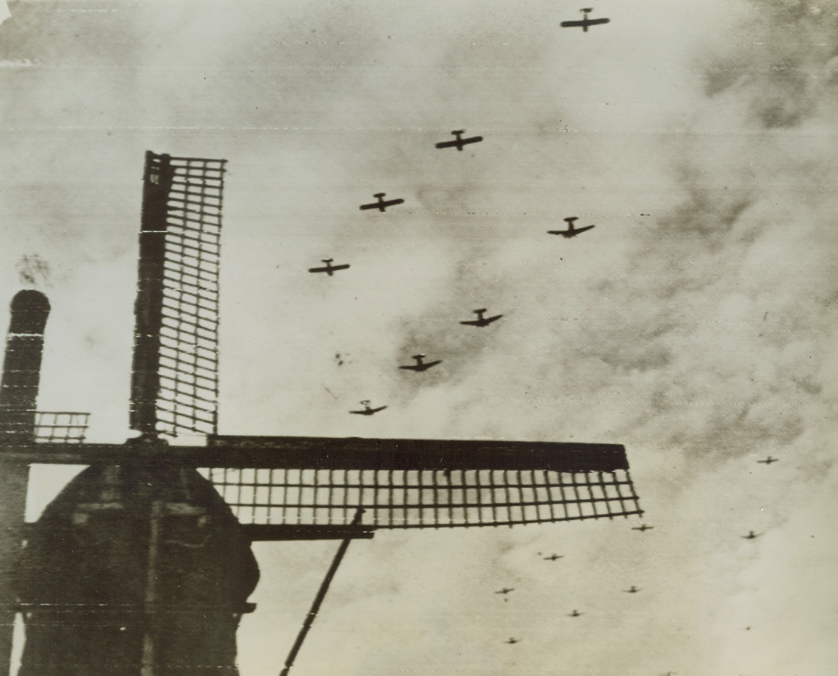 SUPPORT FOR TRAPPED TROOPS, 9/25/1944. American two planes with their gliders, pass over a windmill at Valkenswaad, near Eindhoven, Holland, on their way with reinforcements for airborne troops trapped at Arnhem. Credit: British official photo via U.S. Army radiotelephoto from Acme;