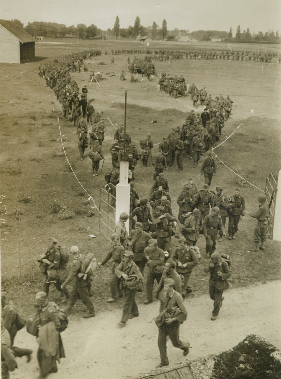 Nazis Surrender 20,000 Strong, 9/22/1944. BEAUGENCY, FRANCE – Arms and equipment handed in, twin endless lines of Germans, part of a huge army of 20,000, are marched through taped areas to prisoner of war cages after their surrender to the United States Ninth Army. Nazis in the armies of occupation from the Loire south to the Pyrenees gave up their weapons to end a bloodless campaign which insured one of the greatest military bargains in modern history. Photo by Charles Haacker, Acme photographer for the War Picture Pool. Credit – WP- (ACME);