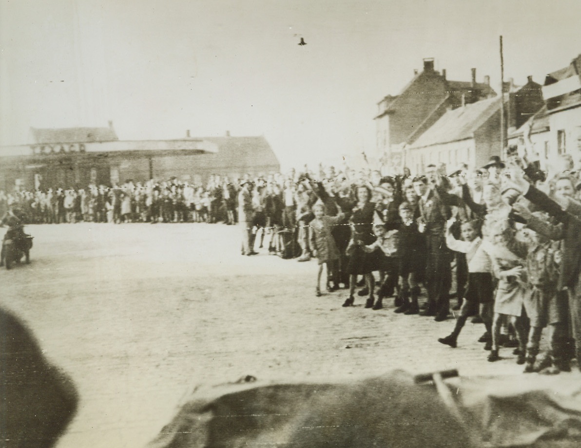 Dutch Welcome, 9/22/1944. HOLLAND – Waving and cheering, Dutch civilians give American Airborne troops a hearty welcome after our boys landed behind German lines and advanced to take the town of Lindhoven. Credit Line (Army Radiotelephoto from ACME);