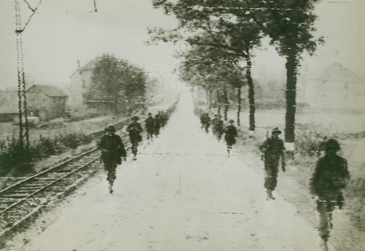 American Troops March in Germany, 9/15/1944. GERMANY – Troops of Gen. Hodges’ 1st Army march along both sides of a road in an endless single file as they advance to the key German city of Aachen. These troops, among the first to enter Germany, made history by bringing war to the Fatherland. Credit – WP –(ACME Photo by Andrew Lopez, War Pool Correspondent via Army Radiotelephoto);