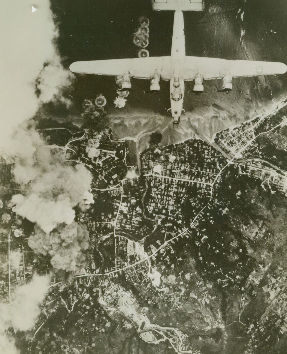 Liberators Blast at Ambon Installations, 9/16/1944. AMBON, CORAN, NETHERLANDS INDIES – As smoke rises from bombed Jap installations, a Far Eastern Air Force Liberator wings its way over the enemy-held town of Ambon on the island of Ceram in the Netherlands Indies. Shipping in the harbor as well as fortifications on the mainland suffered during the large scale bombing attack. As the raiders headed back for their home base, smoke from the hits was rising to a height of 10,000 feet.Official USAAF Photo from ACME;