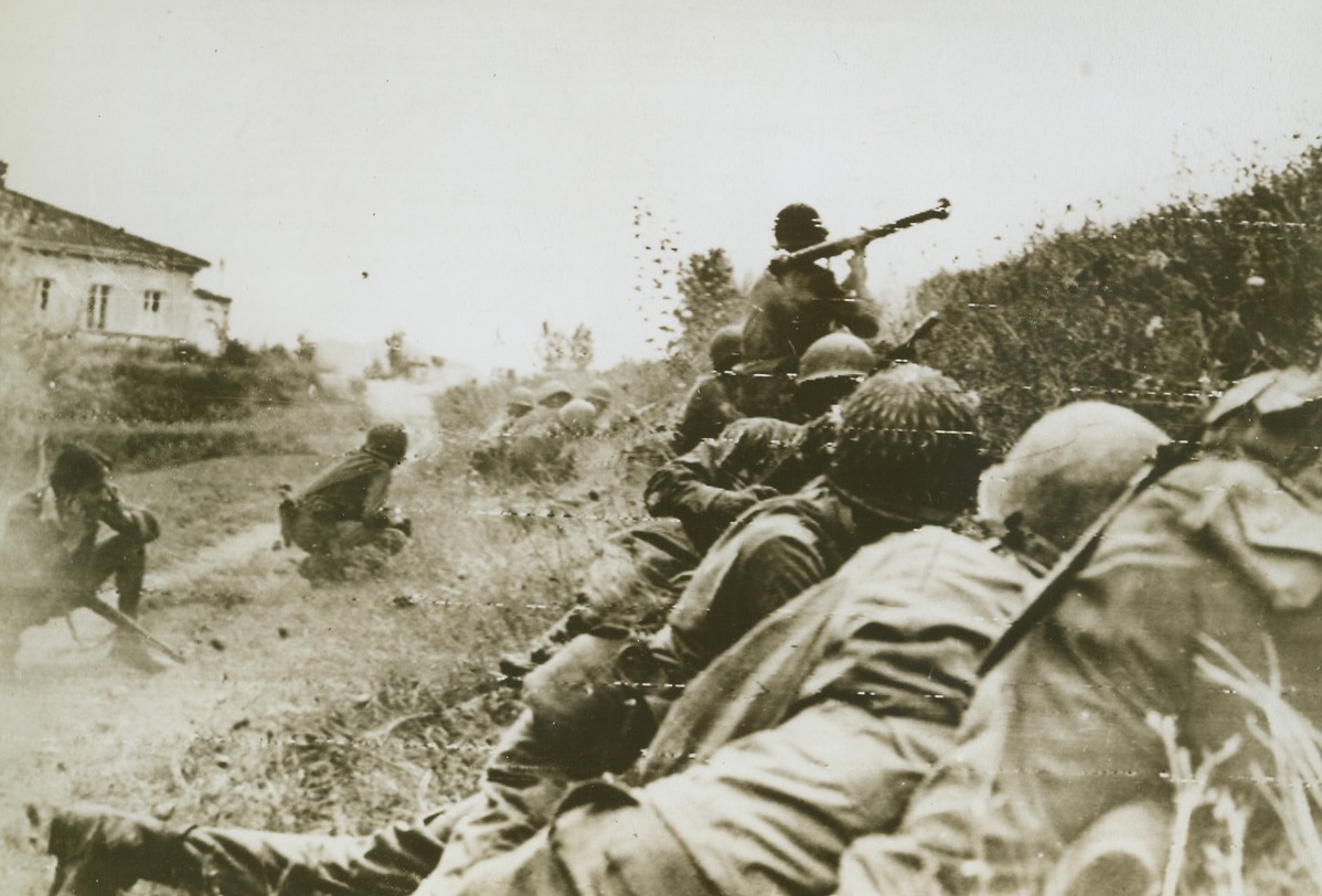 Ninety-Second Lets ‘Em Have It, 9/10/1944. ITALY – Fighting in the most distant position yet reached by Yank troops in Italy, a combat patrol of the all-Negro 92nd Division strikes at an enemy machine gun nest. An Italian partisan (extreme left) crouches and holds his ears as a bazooka shell screams toward the enemy position.Credit (Signal Corps Radiotelephoto from Acme);
