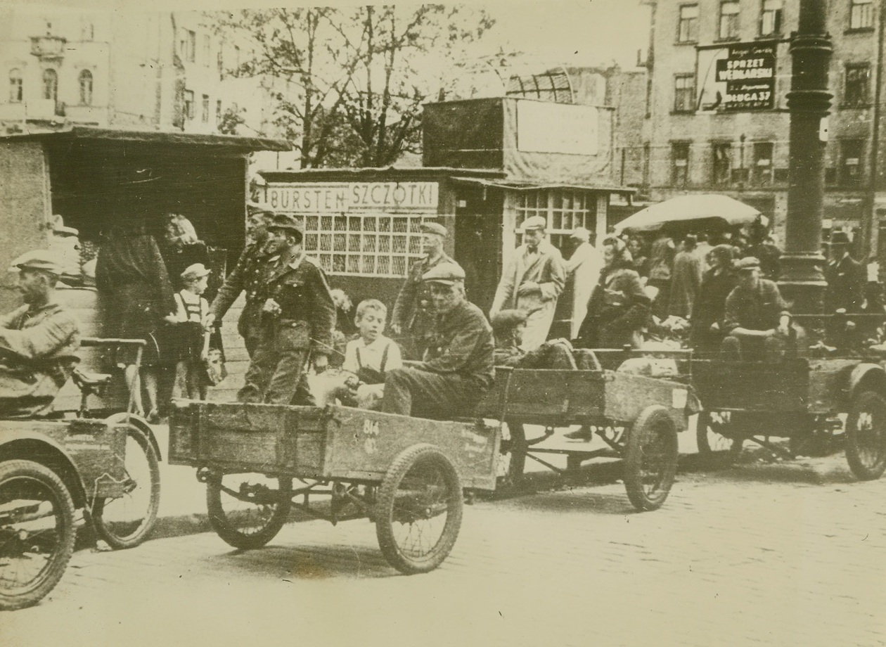 Warsaw Taxis Foot Propelled, 9/20/1944. German soldiers strut down a street in Warsaw while humble bicycle-taxi drivers await hails from Poles who have goods to transport from one part of the city to another. At left two women examine the meager produce in a sidewalk store. This photo, received from Warsaw through secret channels, has just been released by censors for publication. Credit Line (Acme);