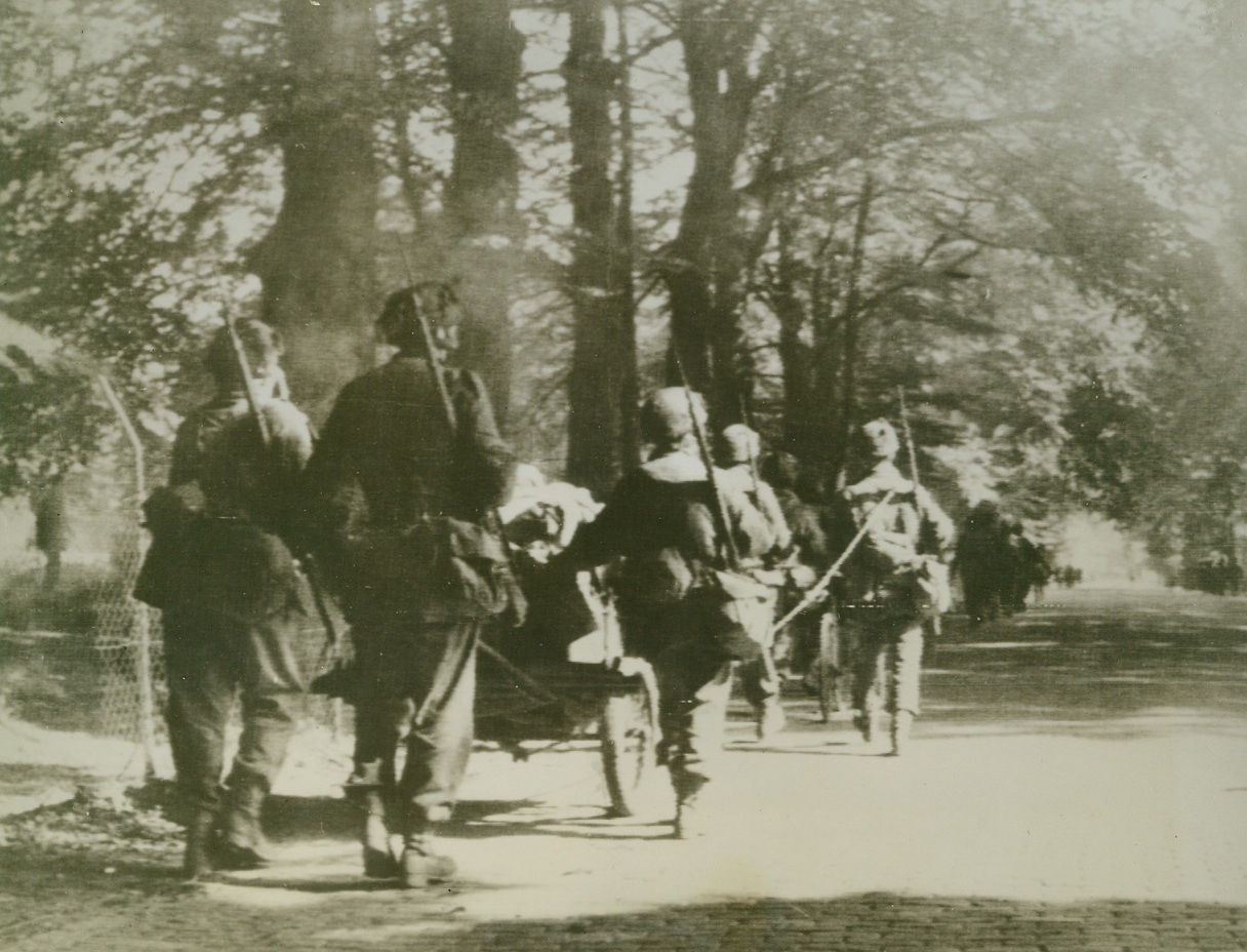 Reinforcements Bound for Arnhem, 9/29/1944. HOLLAND – British paratroopers, who participated in the second landing of the first Allied Airborne Army, advance toward Arnhem. The fighters trundle their armor along in small carts. Credit (British Official Photo from Acme);