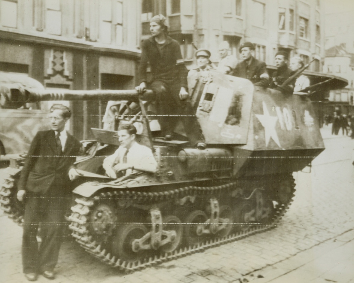 BELGIAN “WHITE BRIGADE” ON MARCH, 9/8/1943. BELGIUM—Riding in captured German vehicles, members of the “White Brigade,” Belgian resistance movement, are shown in the city of Antwerp as they headed for other towns to clear out the German snipers and stragglers. Credit-WP-(ACME Photo via Army Radiotelephoto);