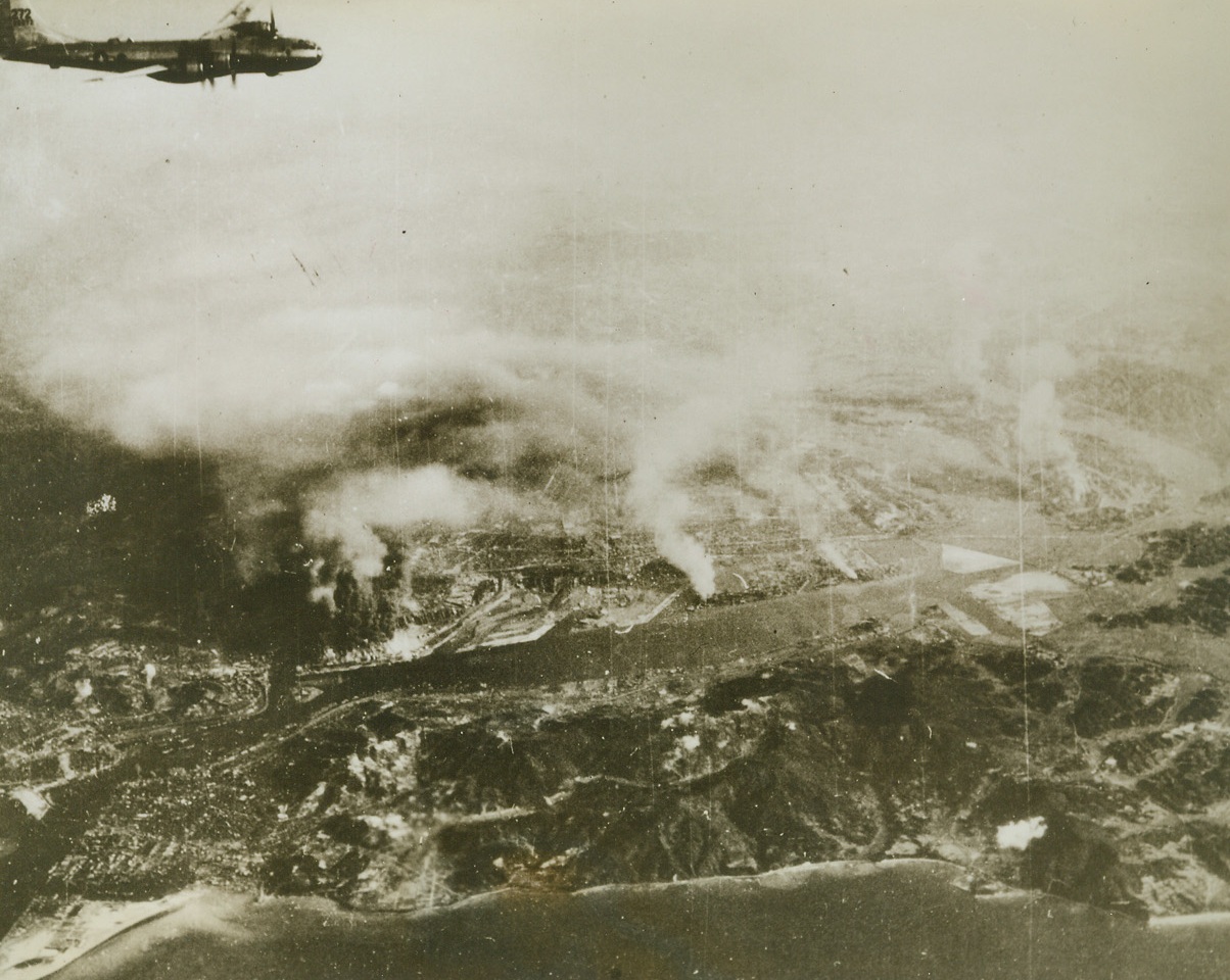 Yawata Blasted by B-29’s Again, 9/8/1944. Japan – Yawata, the “Pittsburgh of Japan,” burns and smokes under the third attack by B-29 superfortresses during their mission of August 20.  This was the first daylight bombing attack of the Jap mainland since Gen. Doolittle’s historic flight.  Note one of the huge planes in upper leftCredit (USAAF photo from ACME);