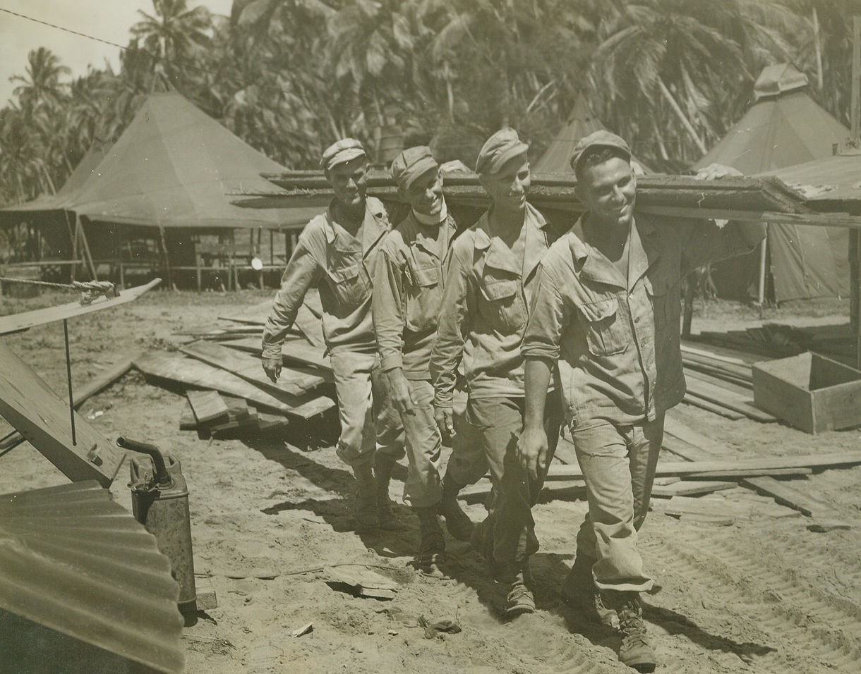A Fighting Family with the U.S. Army, 9/1/1944. AITAPE, NEW GUINEA – The Vanskike family, father and three sons, enlisted in the army at the same time back in 1942 at Galveston, Texas. Since that time they have been together through basic training and are now all with the 32nd Division headquarters carpenter shop on Aitape in New Guinea. The father, whose nickname is “Pop,” served in the last war as a sergeant in the field artillery for 26 months. Here they are, left to right: Pvt. Archie, Pvt. Lewis, Pvt. Clarence, and S/Sgt. “Pop,” hauling lumber for new quarters.  Credit: ACME photo by Tom Shafer, War Pool Correspondent;