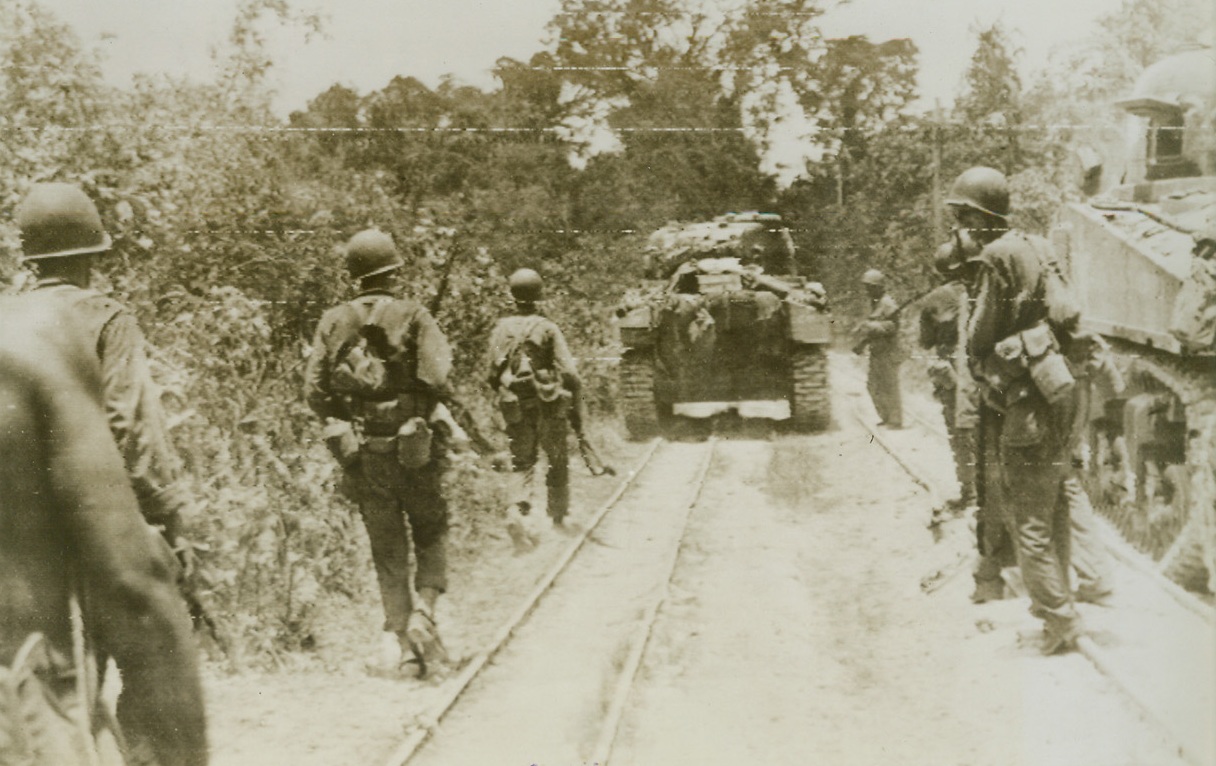 Japs – 50 Yards Ahead, 9/28/1944. Palau Islands – Slowly, gut steadily troops and tanks of the U.S. Army’s 31st division move up along a double narrow gauge railroad to blast a Jap strongpoint only 50 yards from the point where this photo was taken.  Scene is An gaur Island. Credit line (Army radio telephoto from ACME);