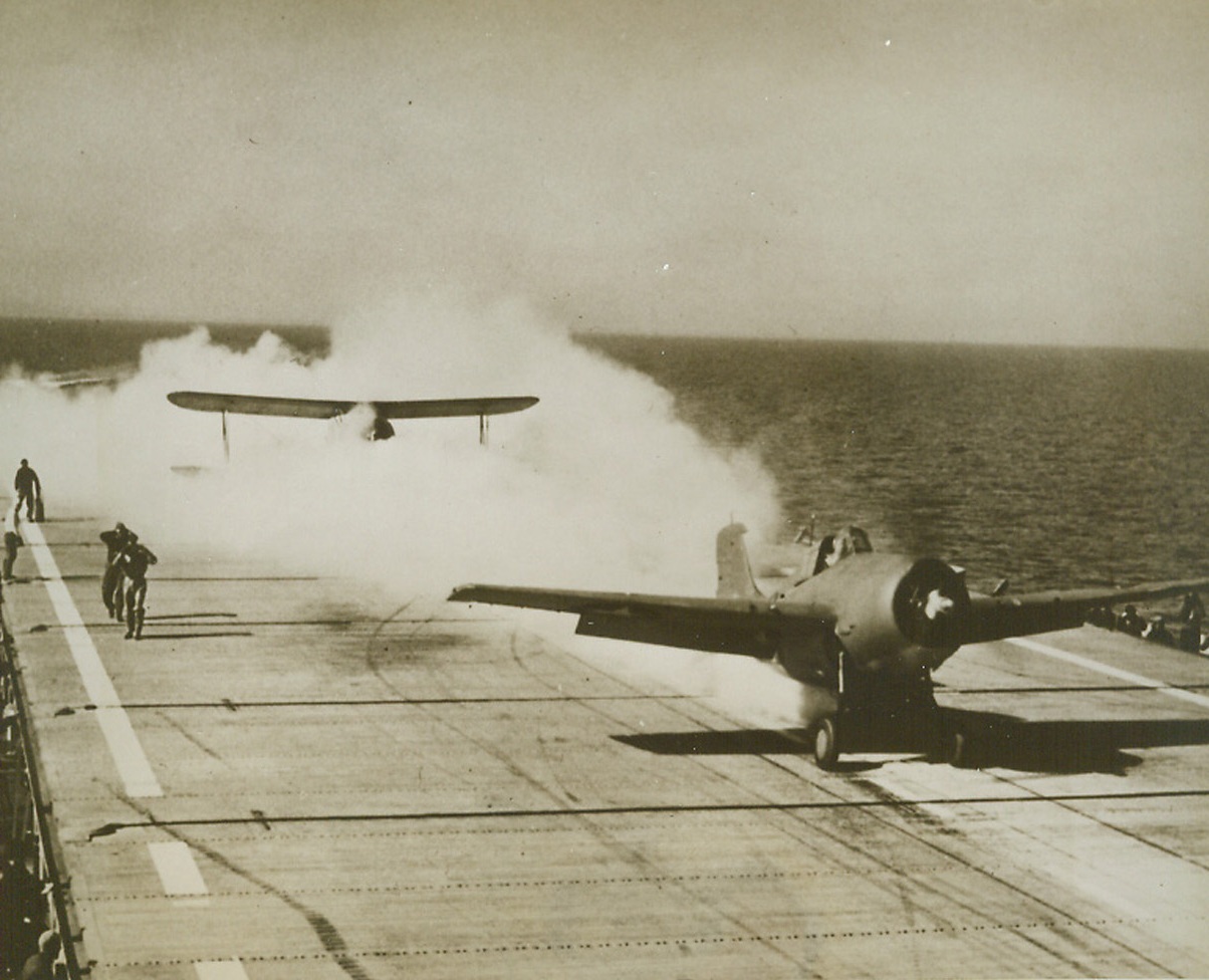 Jet Units and Navy Planes in Take-Offs, 9/8/1944. The Navy announced today that it has developed for immediate use jet propulsion units to assist carrier planes and flying boats to take off with heavier loads, in shorter spaces and at greater speed. The jet units, known as Jato in the Navy, resemble bombs except that they are affixed to the fuselace of a plane rather than under the wings or enclosed in the bays. They contain solid propellent, which includes oxygen, and are ignited by electronically-controlled spark plugs. Escaping steam gives the plane its “thrust.” First carrier takeoff using jet units involved in the same Grumman Wildcat as that used by Capt. Gore in original tests on March 1-4, 1943. This time Commander Leroy G. Simpler, USN, of Lowes, Del., was at the controls as the jet-assisted plane roared into the air on March 18, 1943—with an amazing saving of takeoff space.Credit: U.S. Navy Photo from ACME.;