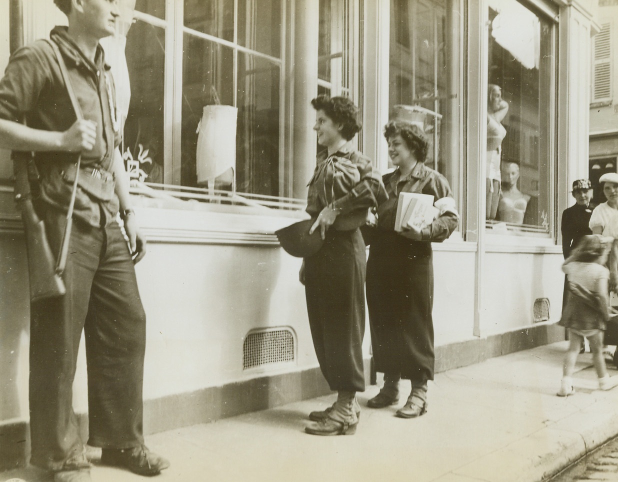 AND PRE-WAR RUBBER, TOO, 9/5/1944. FRANCE – Lt. Margaret Weston, Steubenville, O., and Lt. Patricia Sheridan, Cleveland, O., 80th Army nurses, do a bit of window shopping in Sens, France.  And that’s not a bad looking number, either.Credit: Signal Corps photo from Acme;