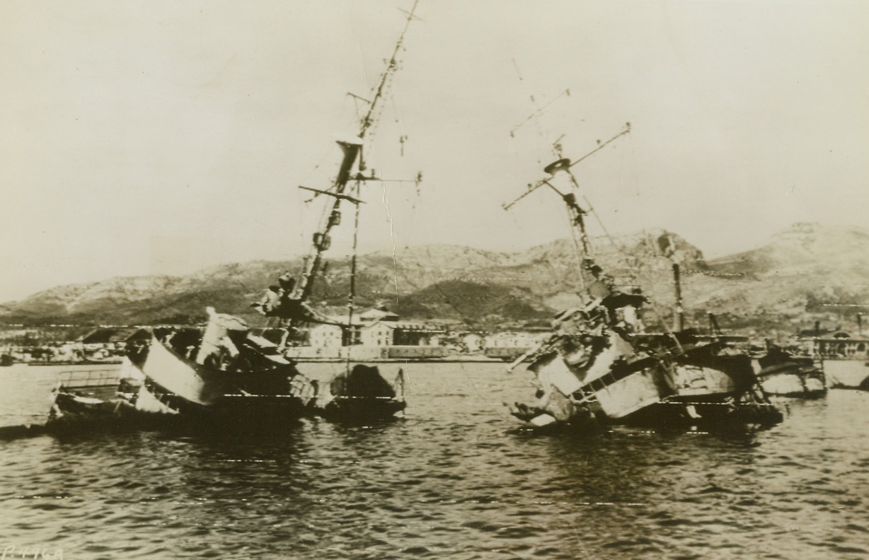 SCUTTLED WARSHIPS, 9/3/1944. TOULON, FRANCE – Only the bridges and masts of this pair of French destroyers are visible as the scuttled ships lay side-by-side in Toulon harbor.  The vessels were sent to the bottom by French patriots to prevent their seizure by the Nazis. Credit: Army radio telephoto from Acme;