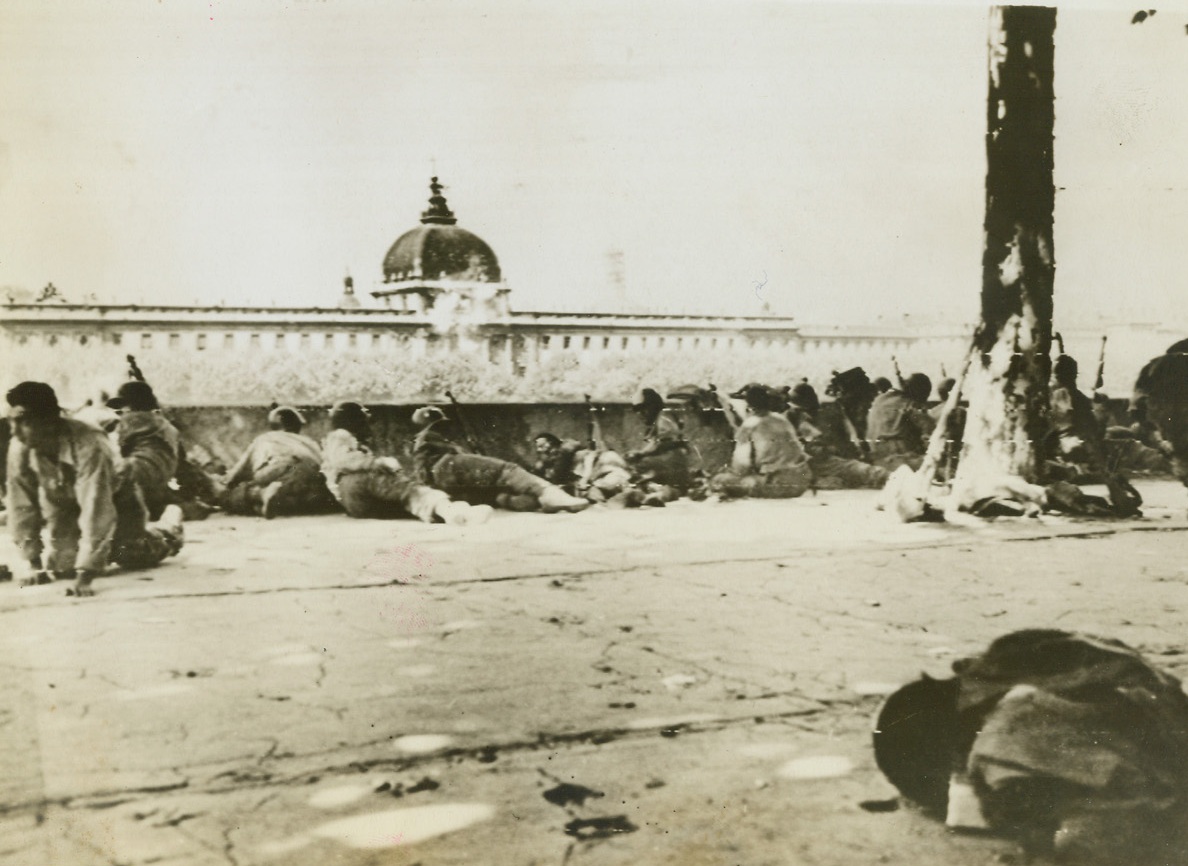 SNIPER BATTLE IN LYON, FRANCE, 9/6/1944. FRANCE—Crouched behind a wall along the Rhone River, Allied soldiers shoot it out with die-hard German snipers and Nazi sympathizers firing from a civilian hospital across the river. Battle began when snipers, hidden in the building after the city fell, opened fire on American engineers constructing a Bailey bridge to ford the waterway. Credit (Army Radiotelephoto from ACME);