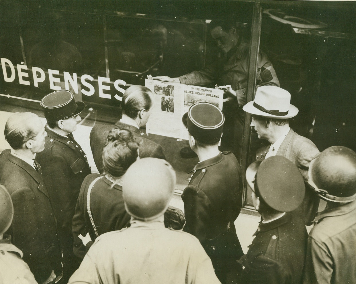 History Repeats, 9/9/1944. France -- Almost 25 years to the day, the first copy of the Stars and Stripes of World War II appears in Paris as did its predecessor, the Stars and Stripes of World War I, service paper for the U.S. forces on the continent. Sgt. Robert J. Collins, Quincy, Massachusetts, displays the paper in the publication’s office as a group of helmeted American soldiers, French officers, gendarmes and civilians looks on. Credit: Signal Corp photo from ACME;