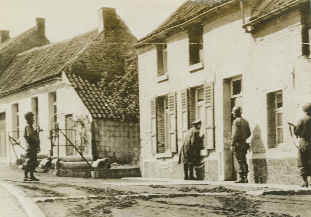 Red Rover, Red Rover, Nazis Come Over, 9/8/1944. France – While American troops with guns at the ready keep guard, a Nazi Captain (center), taken prisoner by the small Yank force which captured the French city of Mons, calls through the doorway of a house telling his men in hiding there to surrender. Credit: Army Radiotelephoto from ACME;