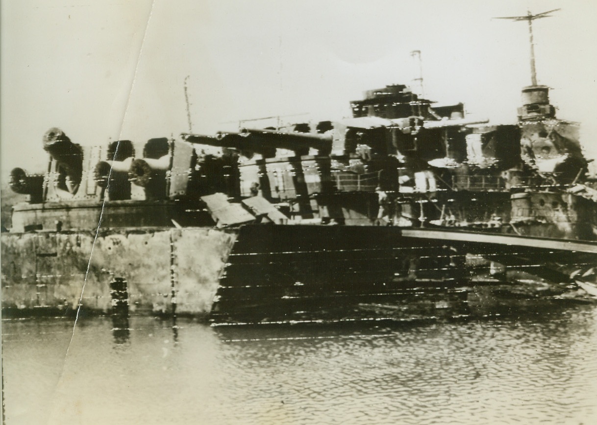 Punished by Both Sides, 9/3/1944. Toulon, France – The French battleship “Dunkerque,” which took punishment from both the Allies and the Germans, lays partly sunken in Toulon Harbor. The ship was a target for Allied bombardiers when she was in German hands, and a victim of retreating Nazis who cut off her big guns. Credit: U.S. Army Radiotelephoto from ACME;