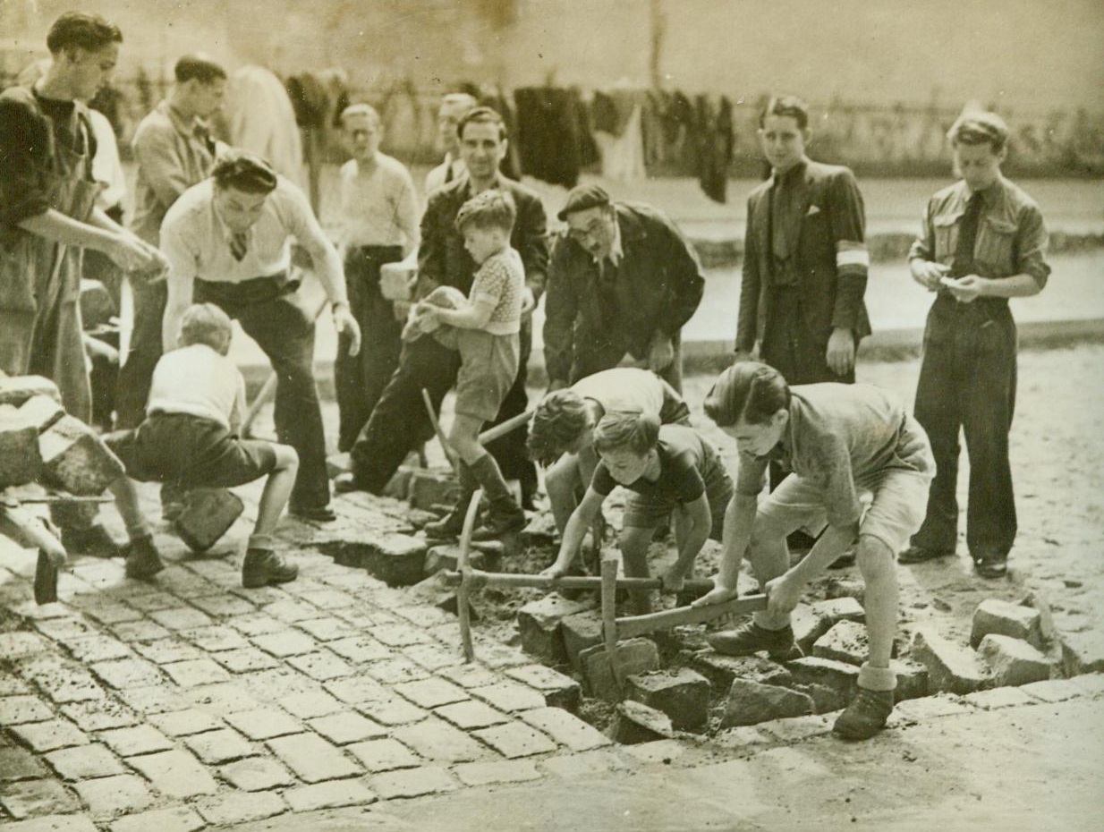 Echoes Of A Bygone Dau, 9/8/1944. Paris -- Reminiscent of the French Revolution days is this picture, made as another Revolution was in progress - When the French people again rose against tyranny, just as they did in the first. Here French people, young and old, work feverishly to tear up the paving stones in the street to make barricades against the Germans, as the French Forces of the Interior rose against the Nazis. This picture was made by an FFI photographer in the week before Paris fell, when the French people were fighting to wrest their capital from the Germans before any Allied troops had entered the city. 9/8/44 (ACME);