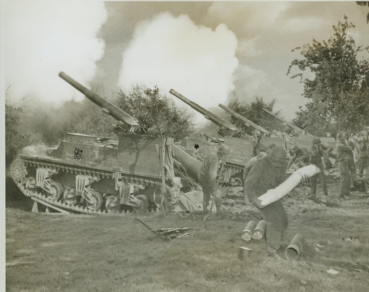 First American Heavy Guns to Fire into Germany, 9/16/1944. Here is a battery of American 155mm. self-propelled guns, mounted on Sherman tank chassis as they fired into the village of Bildehen, Germany, which is located six kilometers southwest of Aachen on the Liege-Aachen road. They opened the barrage with 21 rounds of high explosive shells each weighing 100–pounds.  Credit: (Acme Photo by Andrew Lopez for the War Picture Pool);