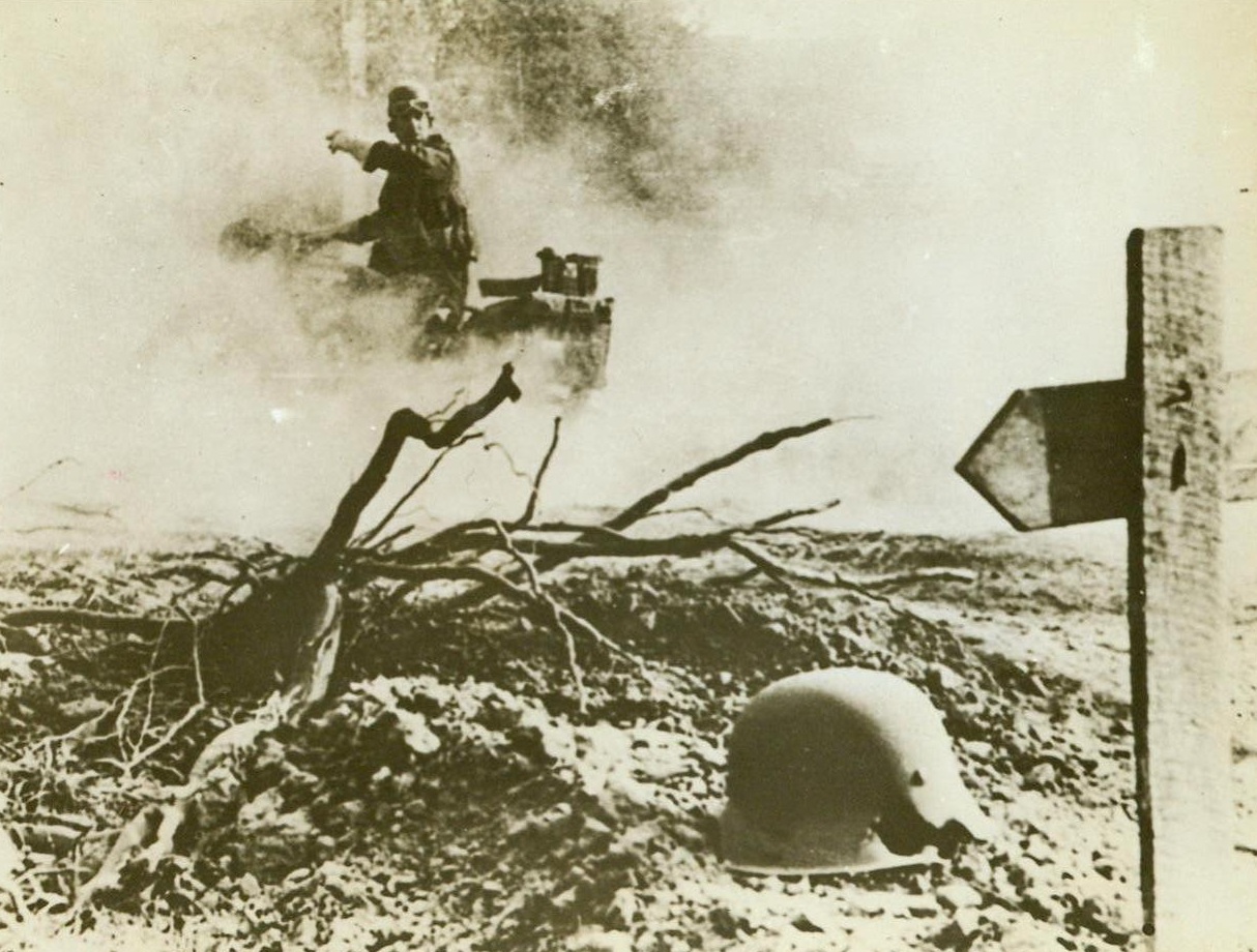 Vignette Of War, 9/17/1944. France – All but obscured by rising dust, this British dispatch rider moves with the British Army in pursuit of the Germans. All along the roadside is evidence of the enemy defeat, graves, unburied dead, scattered helmets and other equipment.  9/17/44 (ACME);