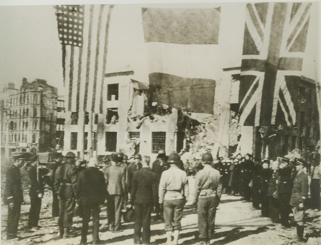 Another French City Liberated, 9/26/1944. Under huge American, French and British flags, Maj. Gen. Troy H. Middleton turns control of the City of Brest over to Mayor Jules Lullien. The ceremonies took place on the same spot where the city was surrendered to the Nazis four years ago. Gen. Middleton is commanding general of the 8th Corps. Credit: (Army Radiotelephoto from ACME);