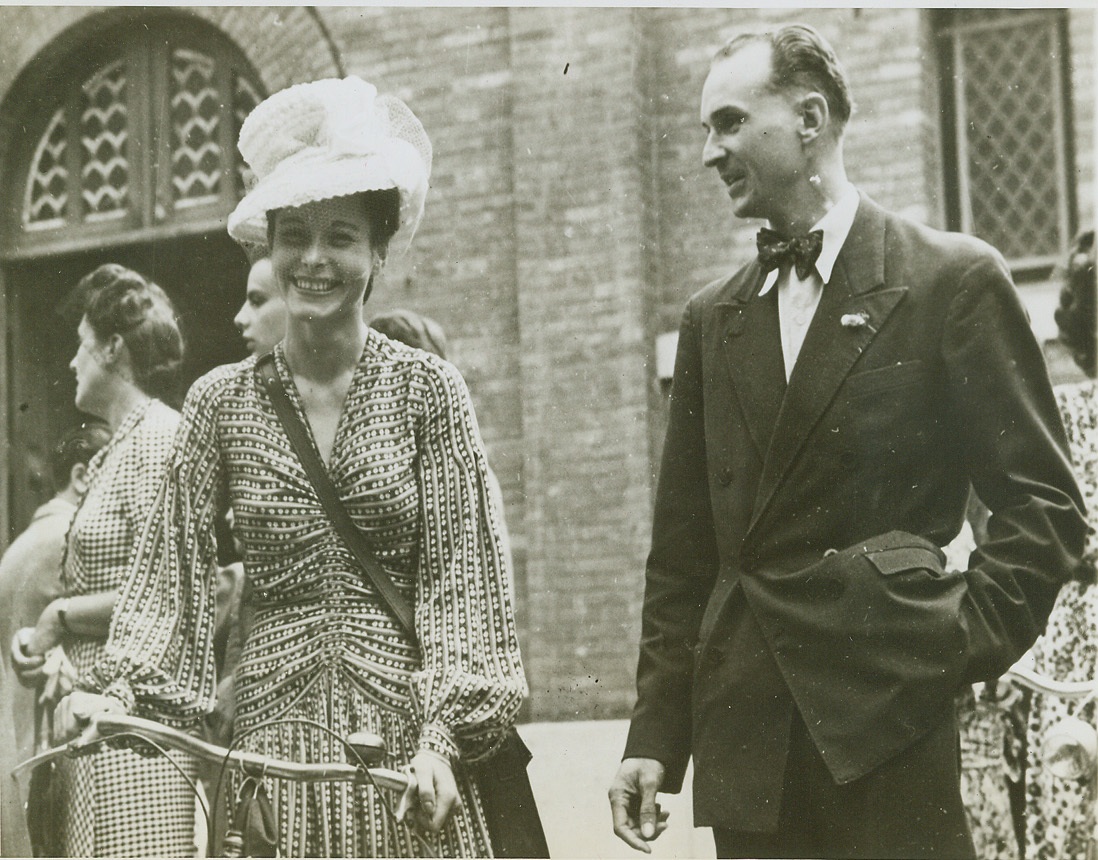 Fashionable Frou-Frou, 9/1/1944. Paris—This fashionable young Parisienne turned out in the full glory of a new chapeau to welcome the liberators to her city. The chic bit of feminine frou-frou, created on an adaptation of the English “beefeater” hat frame, it is made of rows and rows of datingy lace, decorated with a ribbon bow and veiling. One thing foretold the hardships which gay Paris has undergone—the young lady arrived via bicycle instead of car. Credit: Official US Army photo from ACME;