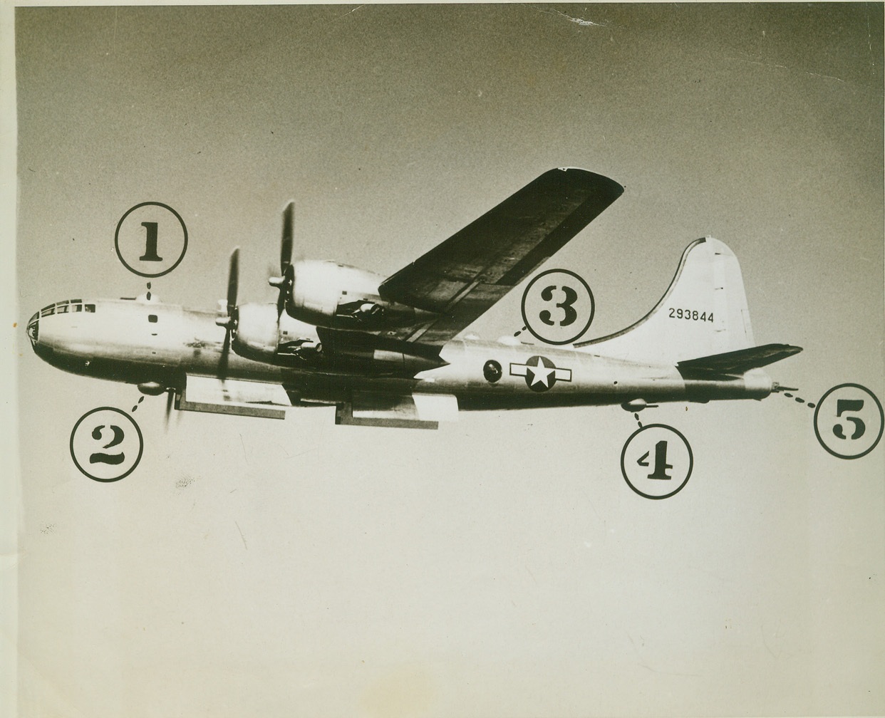 Superfortress Armament Revealed, 9/10/1944. Seattle, Wash.—Touched out of previous photographs of the B-29 Superfortress, the plane’s gun turrets are now revealed. The numbers identify the five turrets-(1) and (2) are the front upper and lower turrets; (3) and (4), the rear upper and lower; and (5) is the tail turret, which is equipped with a 20 mm cannon as well as the two .50 caliber machine guns which are found in all the turrets. All armament is fired by remote control. Credit: ACME;