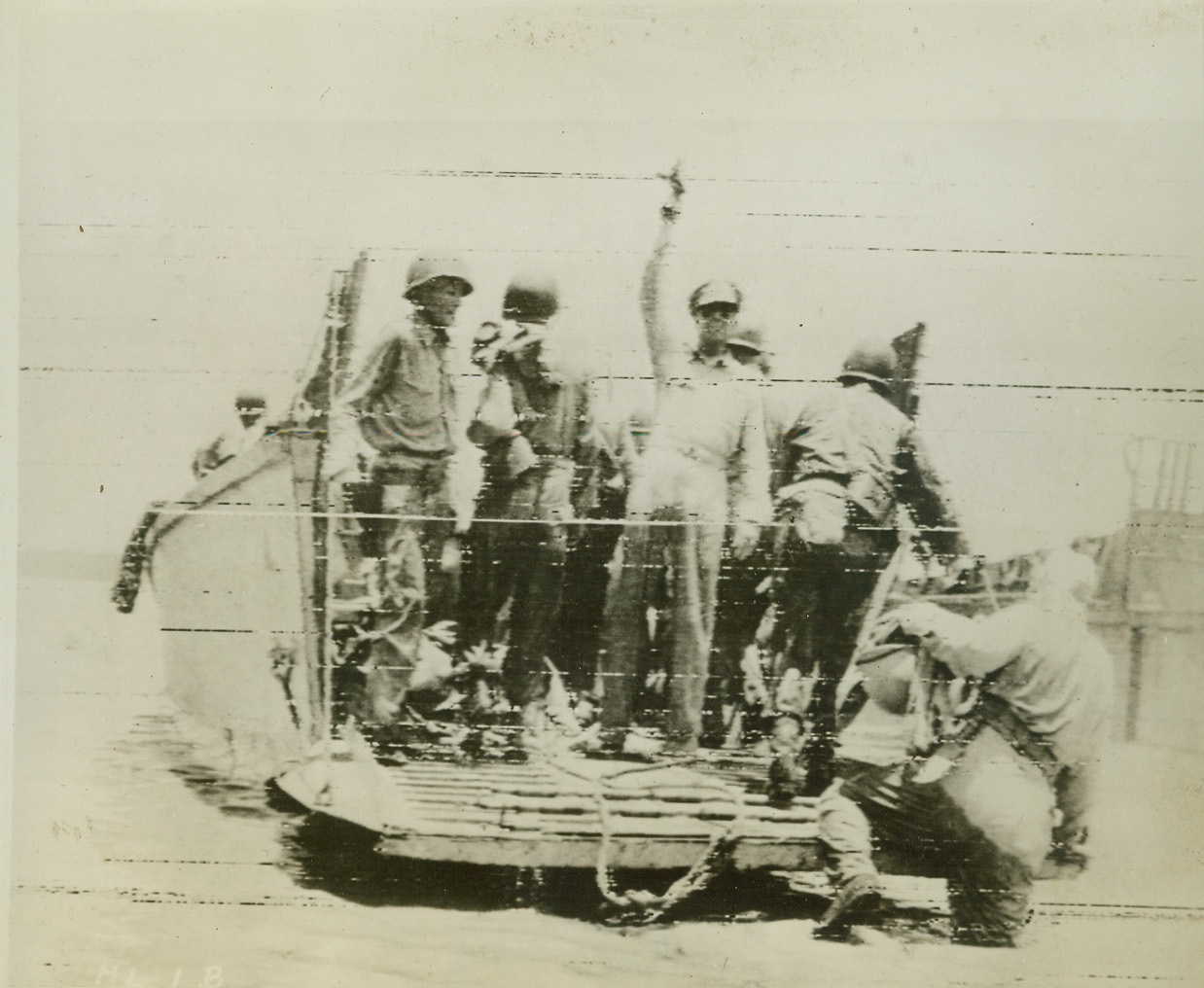 Four-Star Farewell, 9/17/1944. Moratoi Island—Waving his hand in farewell, General Douglas Macarthur leaves Moratoi Island after the successful Allied invasion of the Halmahera Group. A landing barge takes him away from the shore after his tour of the newly-established beachhead. Photo by ACME photographer Frank Prist, Jr. Credit: ACME photo via Signal Corps radiotelephoto.;
