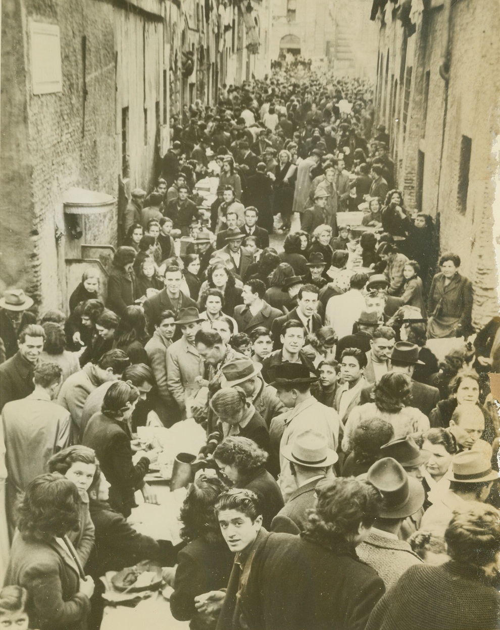 BLACK MARKET OPERATES IN BROAD DAYLIGHT, 1/2/1945. ROME, ITALY – At Via Tor di Nona, one of Rome’s chief black markets, business is going on as usual. There was a slight slackening of pace following several recent incidents where black market pastry shops were looted, but in two or three days the crowd was back in full force. Credit: ACME;