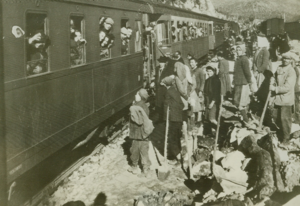 Democracy, Too, Makes Trains Run, 1/23/1945. Italy—Admiring Italians look on as the first civilian passenger train to operate between Rome and Naples since 1943, arrives at Formia Station. Credit: OWI radiophoto from ACME.;
