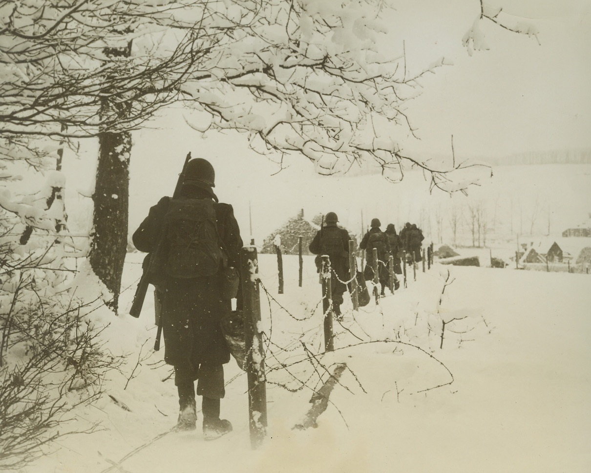 YANKS ADVANCE ON HOUFFALIZE, 1/24/1945. Infantrymen of General Patton’s third Army, dressed against the cold, slog their way over snow-covered countryside to occupy Lutrebois during drive on Houffalize.Credit: Acme;