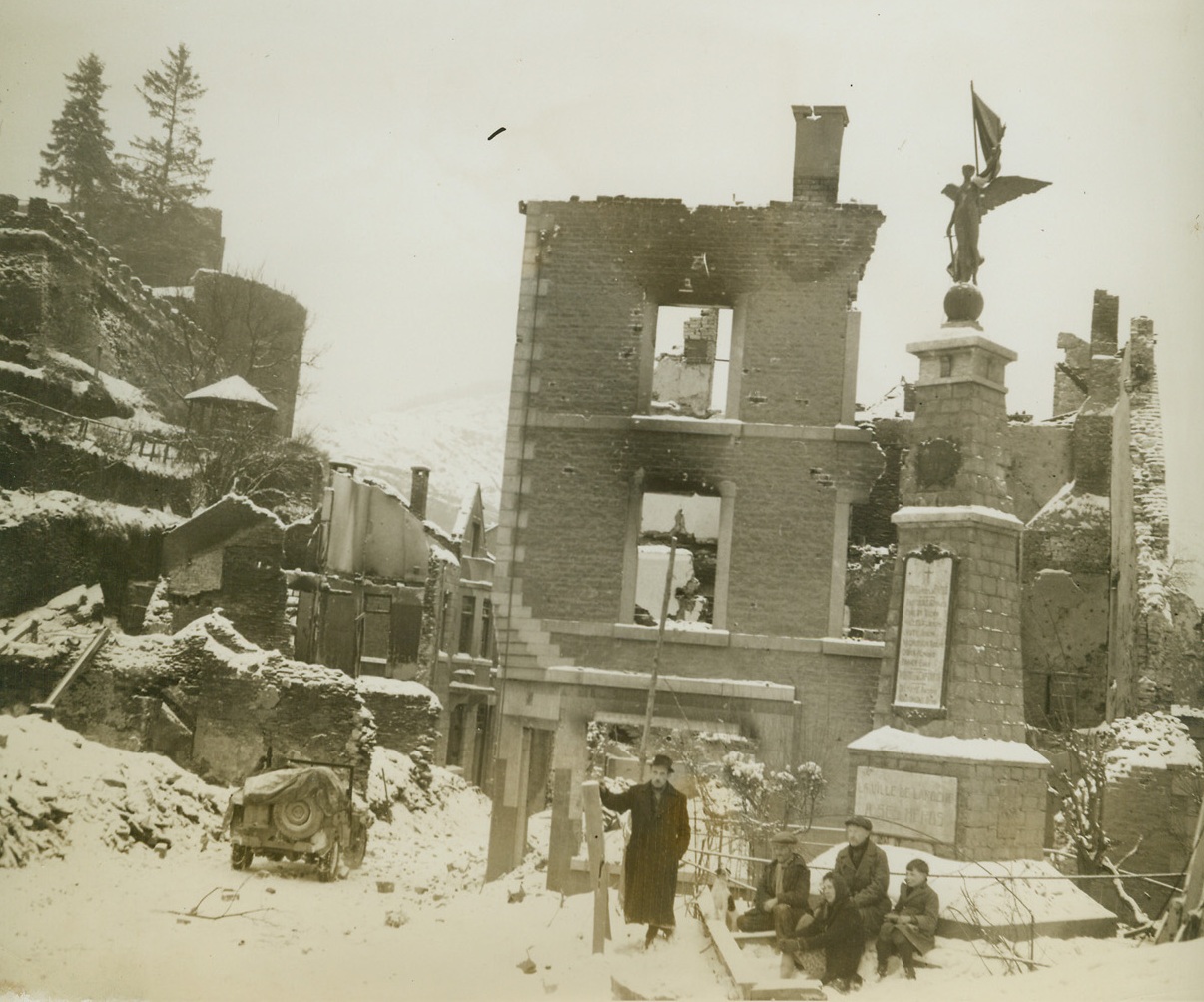 Victory Looks Down on Beaten La Roche, 1/19/1945. BELGIUM – Civilians of the Belgian town of La Roche stand beneath the winged victory symbol, memorial of World War I, against a background of destruction caused by battles in this world-wide struggle. Residents of city had returned to their homes after Yanks had forced Nazis to retreat to hills. Photo by Acme photographer, Harold Siegman, for the War Picture Pool.Credit  -WP- (Acme);