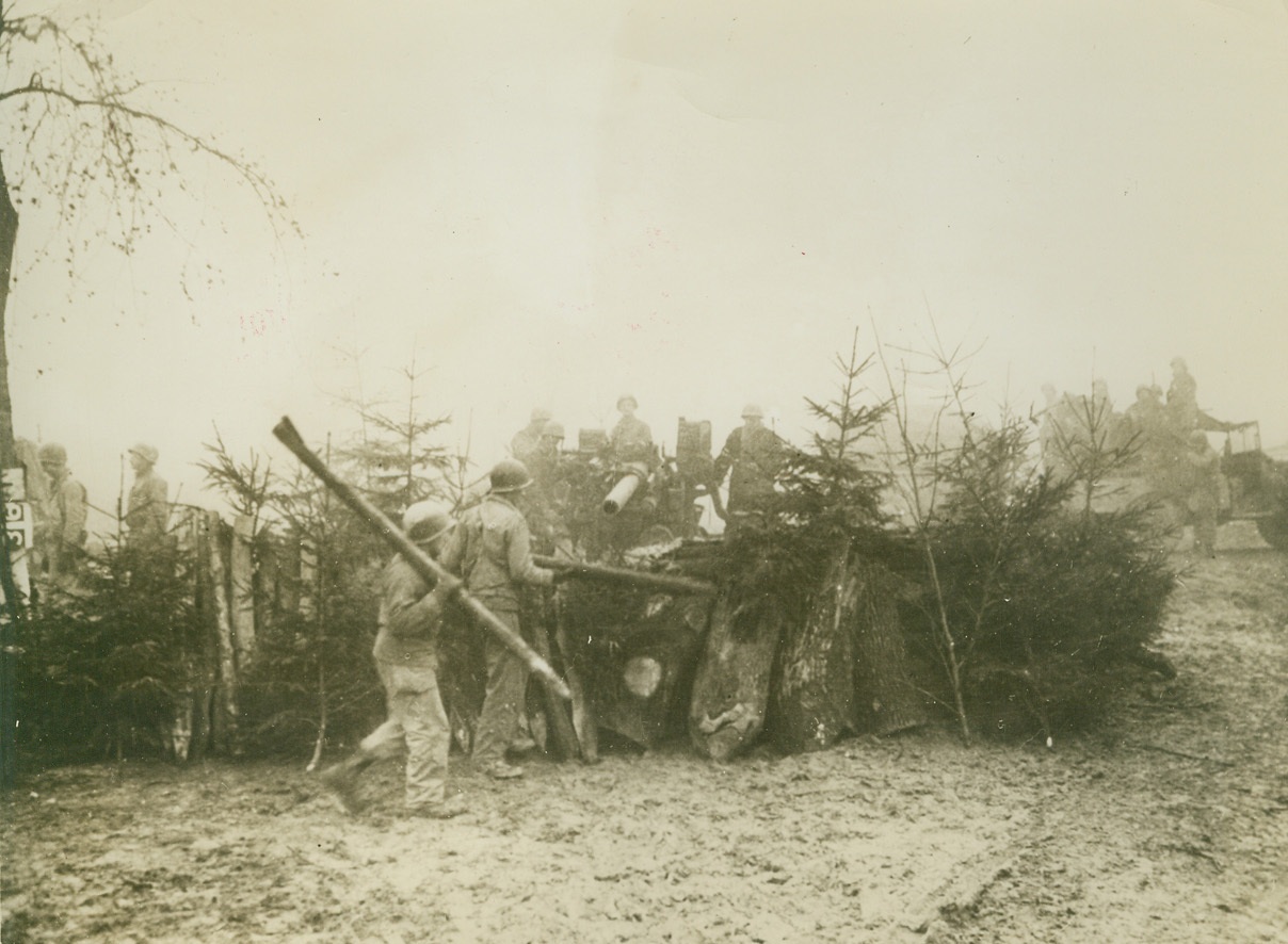 First Pictures of Meuse Offensive, 1/2/1945. WESTERN FRONT – American artillerymen setting up a road block, including Christmas trees, with a 90 mm gun in the Allied drive to stem the German advance to the Meuse River.  Credit Line  - WP – (Acme photo by Harold Siegman, War Pool Correspondent);