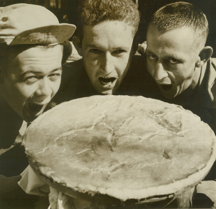 Hey Maw? Bring on the Castor Oil, 1/29/1945. Luzon, Philippines – There’ll be a hurry call for castor oil on the Luzon front if these gee eyes make this monster pie disappear.  Left to right: Pfc William Sheppard, Auburn, Ill.; T/4 Charles Chaw, Eudora, Miss.; and T/5 Robert Koon, Booneville, Miss., are about to take healthy bites from the pie they baked themselves.  Photo by Willard Hatch, ACME photographer for the War Picture Pool. Credit line –WP- (ACME);