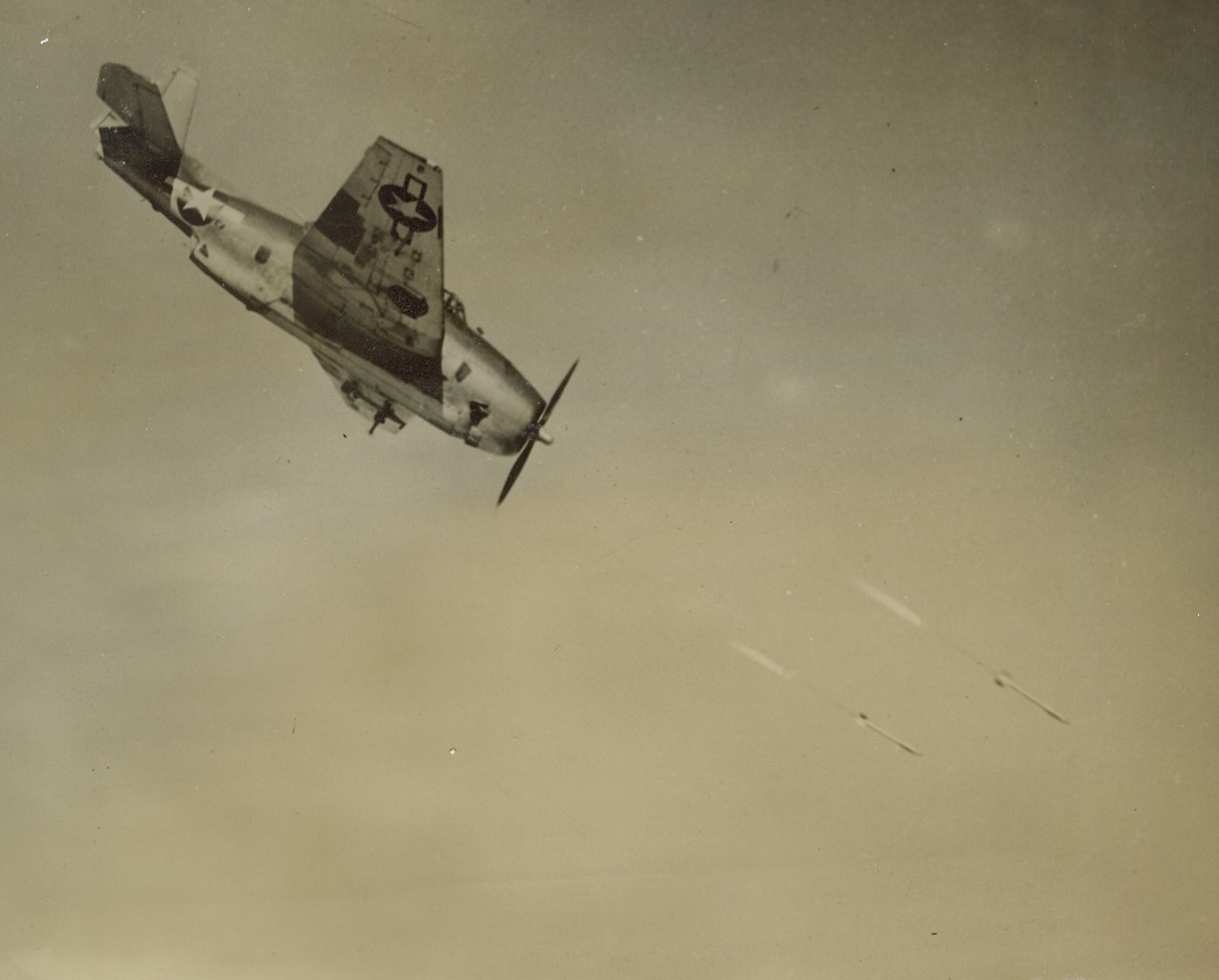 Rockets Away, 1/26/1945. Inyokern, Calif.—Rockets leave flaming trails as they zoom from the undercarriage of a Navy flighter plane during practice firing over the Mojave Desert at the Navy’s 1025 square mile Inyokern testing station. The test area, larger than Rhode Island, is the scene of extensive experimentation by Navy and Marine Corps air and ground forces in the use of the rocket. Credit: U.S. Navy photo from ACME.;